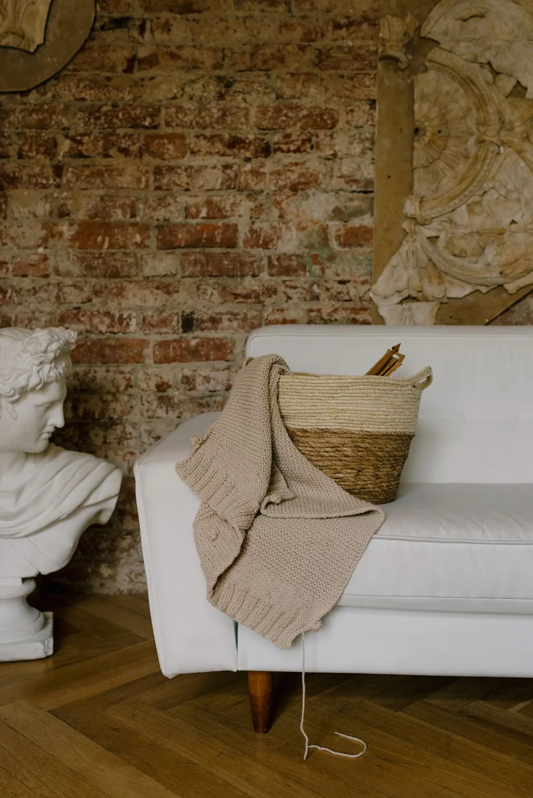 Woven basket and a blanket beside a sofa