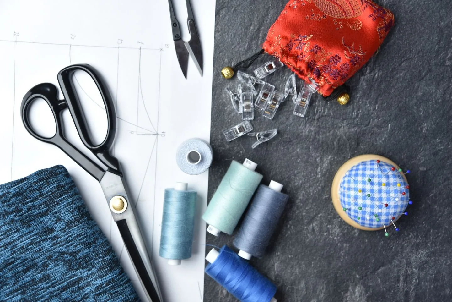 Sewing tools, thread and fabric laid out for a project