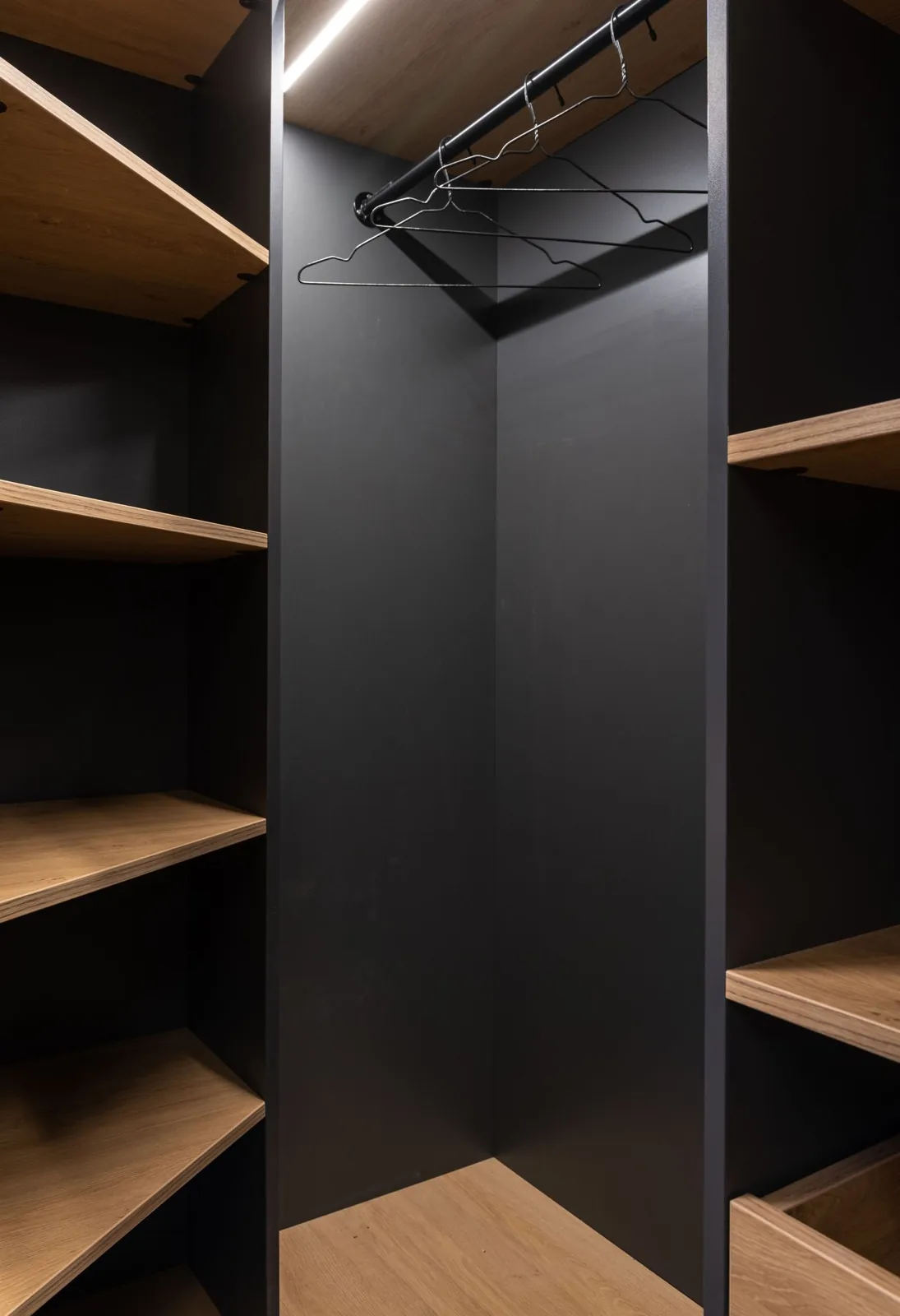 Open cupboard with separate shelves and a hanging rail