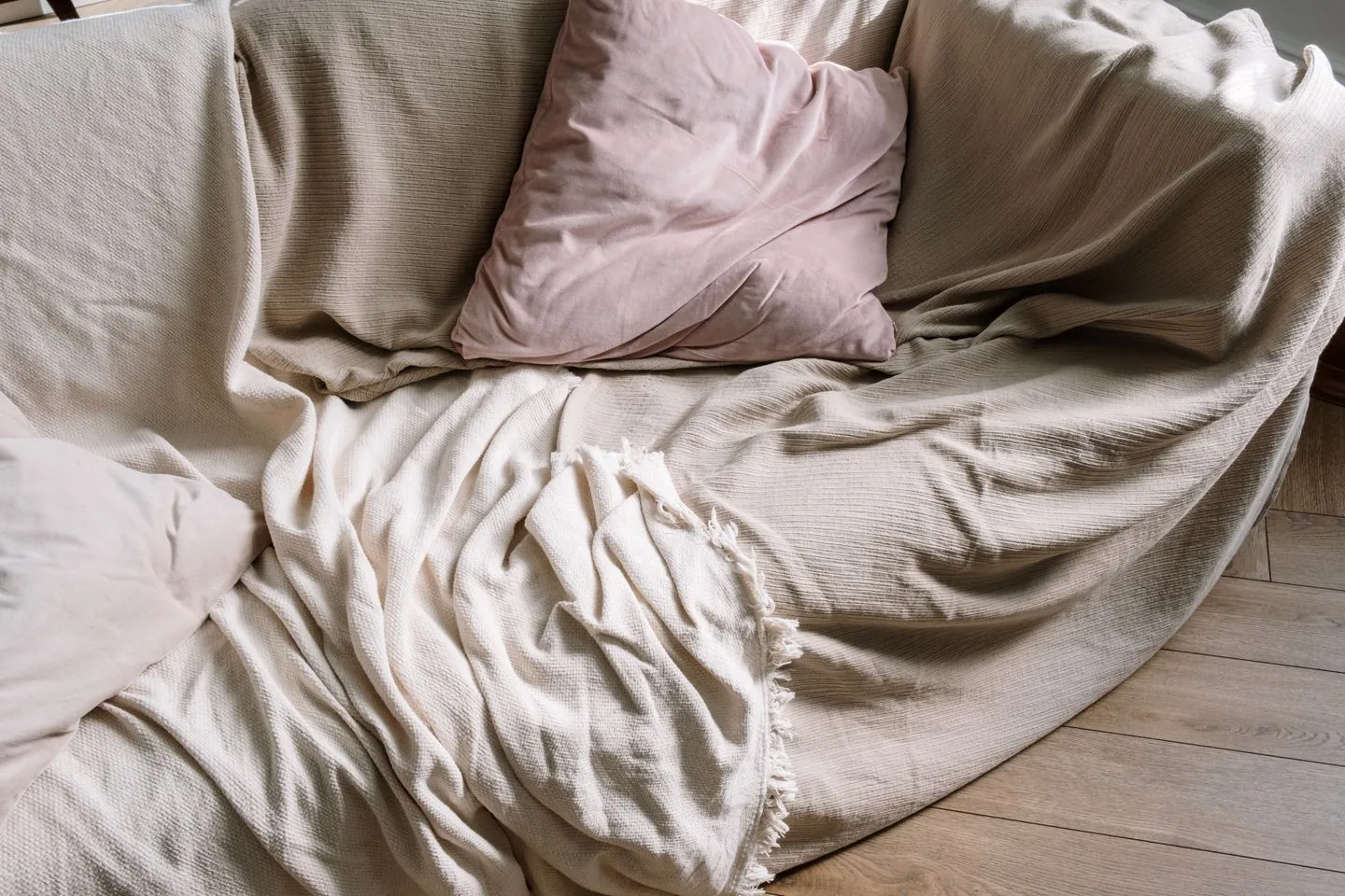 Sofa refreshed with soft cushions and a draped throw