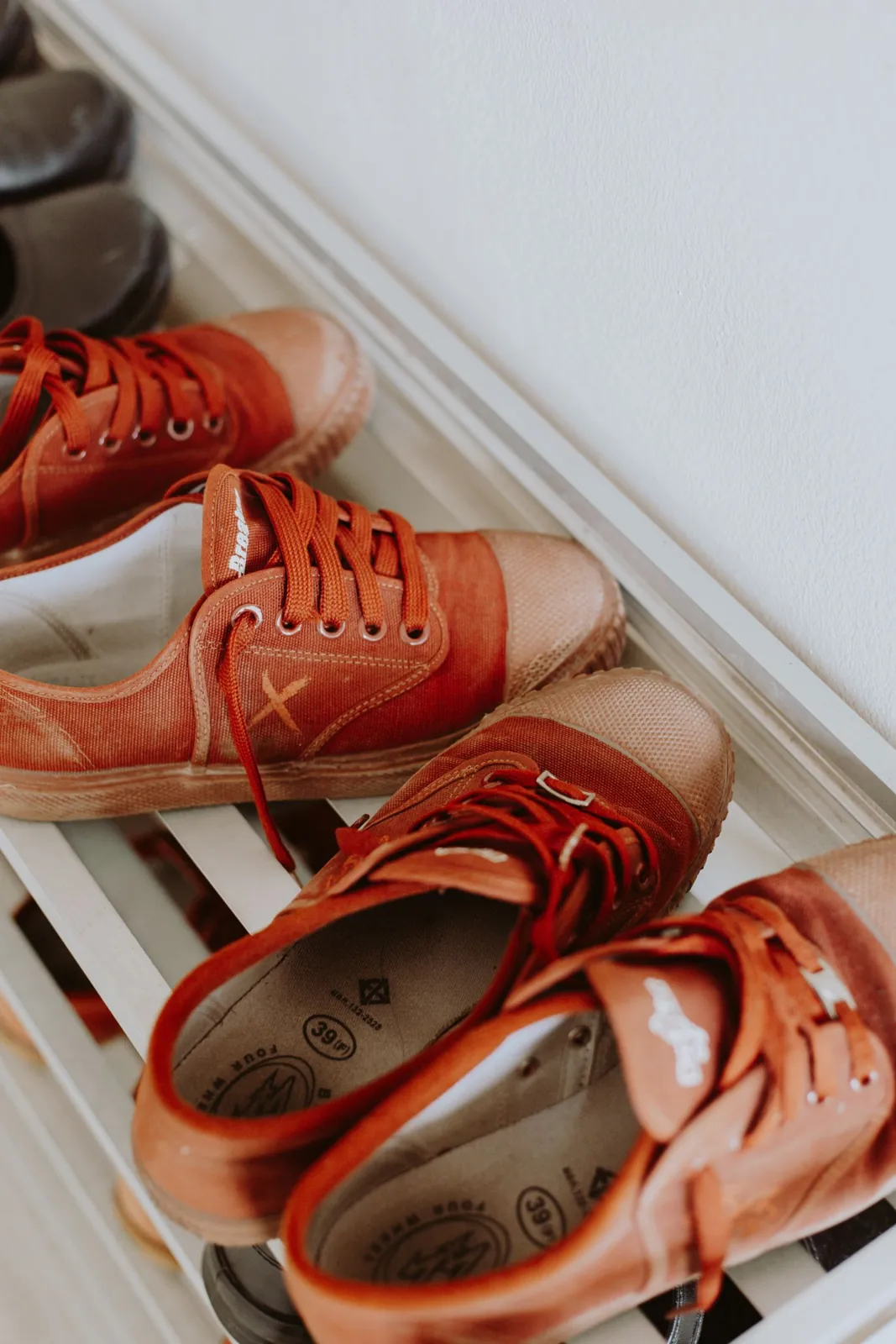 Canvas shoes placed on a white shoe rack