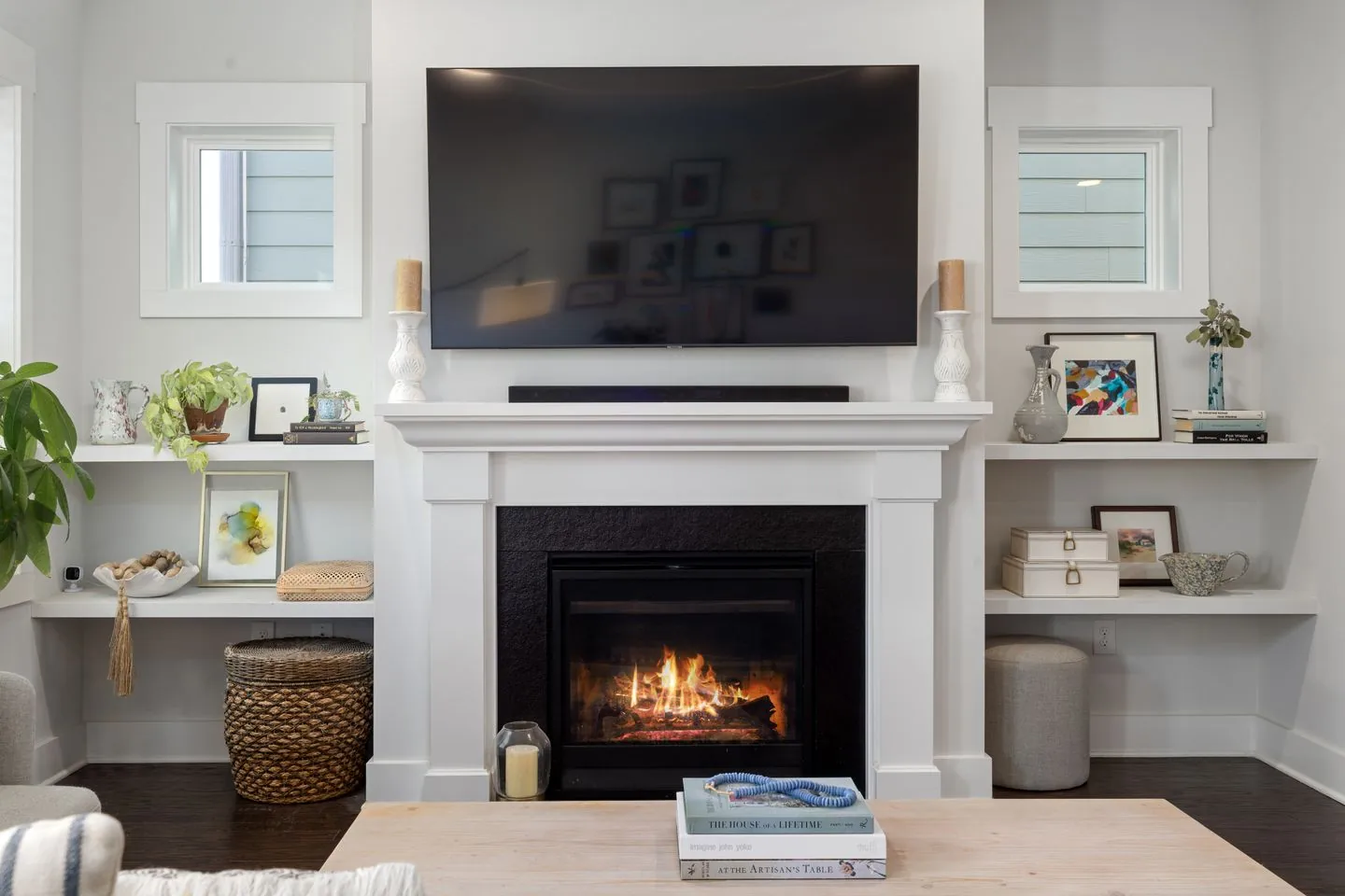 Wall-mounted television above a fireplace and low cabinet