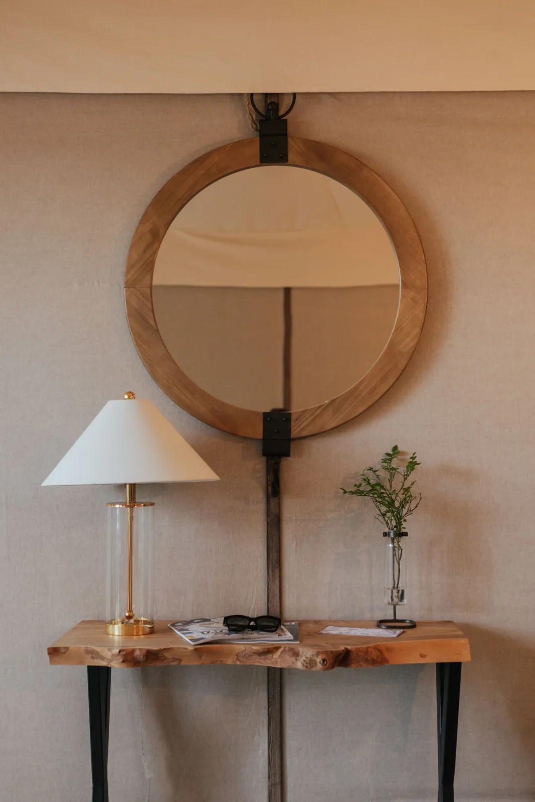Console table with a round mirror and small lamp
