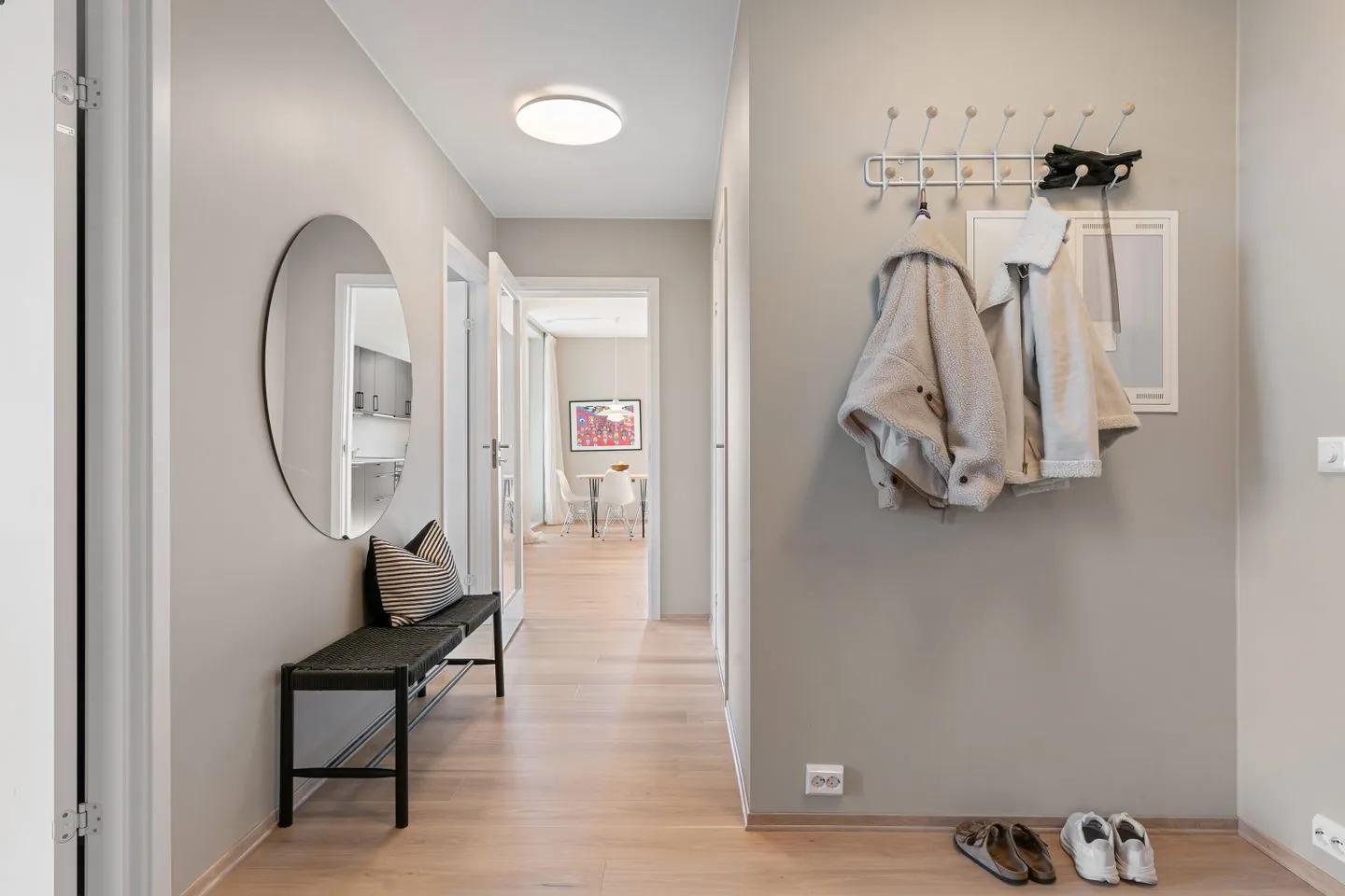 Entryway with coat hooks, shoes, a bench and mirror