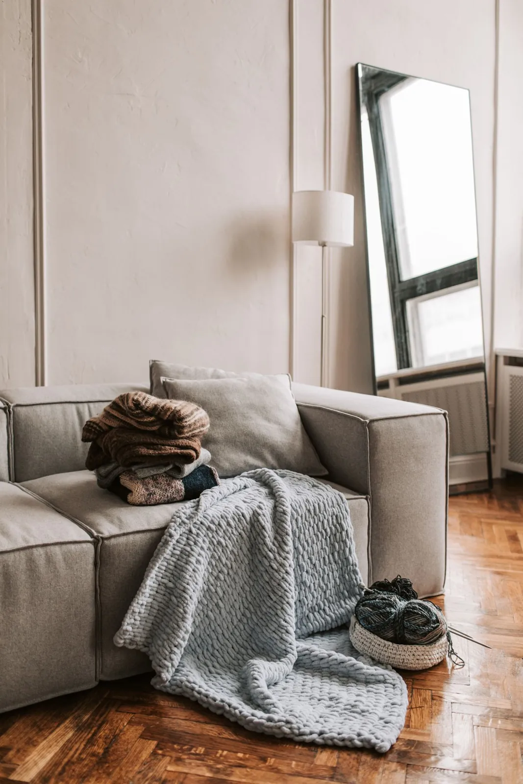Knitted layers and a soft throw on a sofa