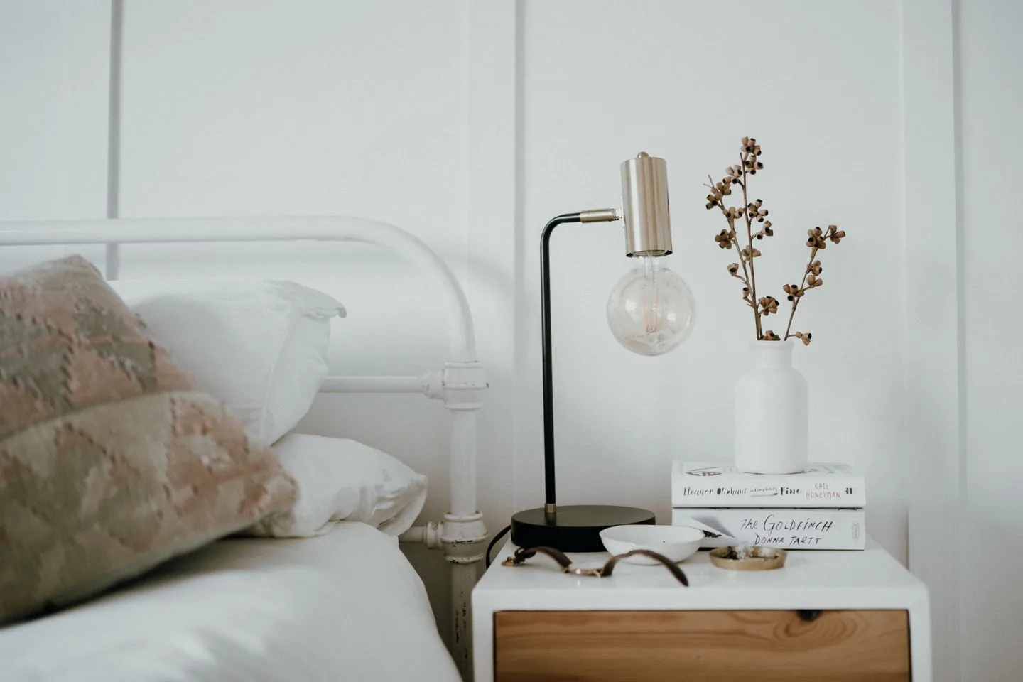Bedside table with a lamp, books and a small plant