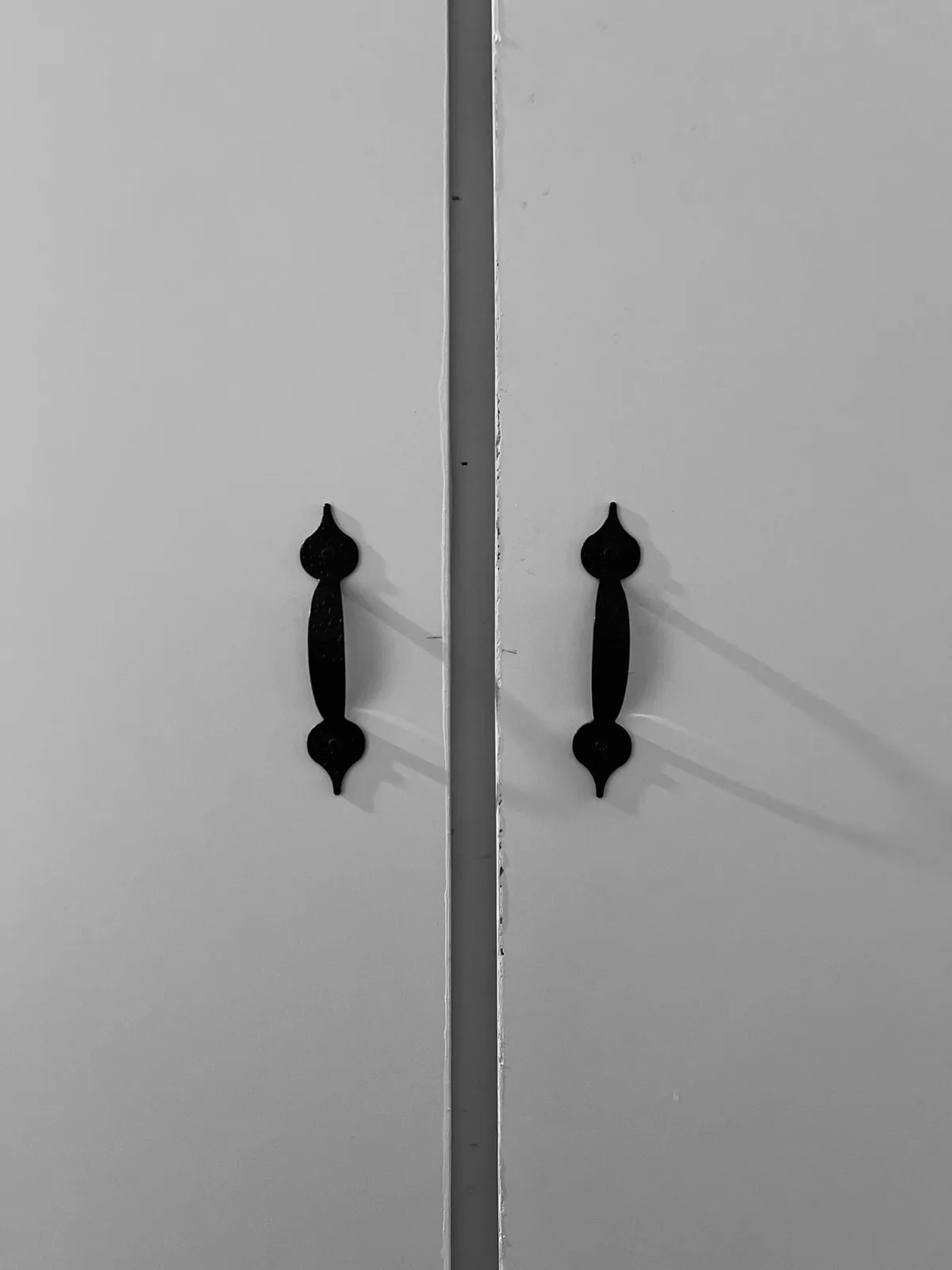Dark handles against white cabinet doors