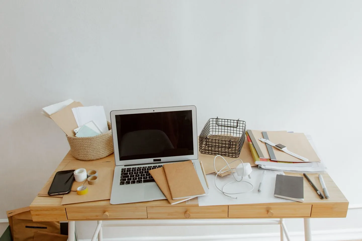 Laptop and stationery on a compact wooden desk