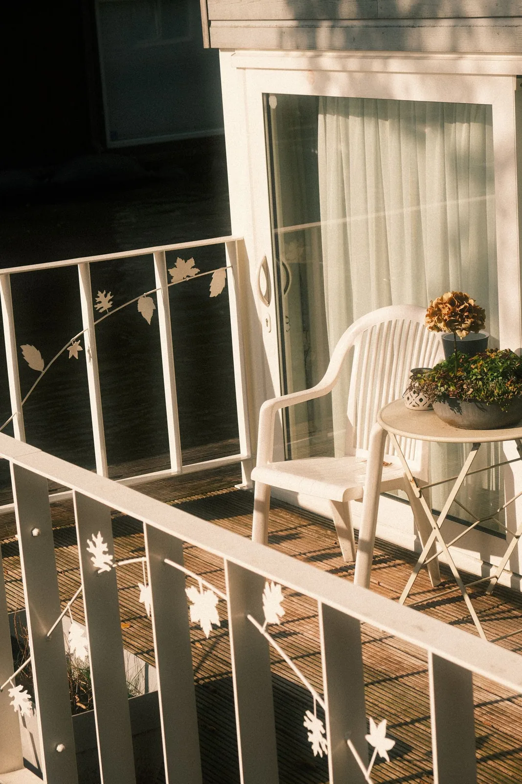 White balcony chair beside a small table and plants