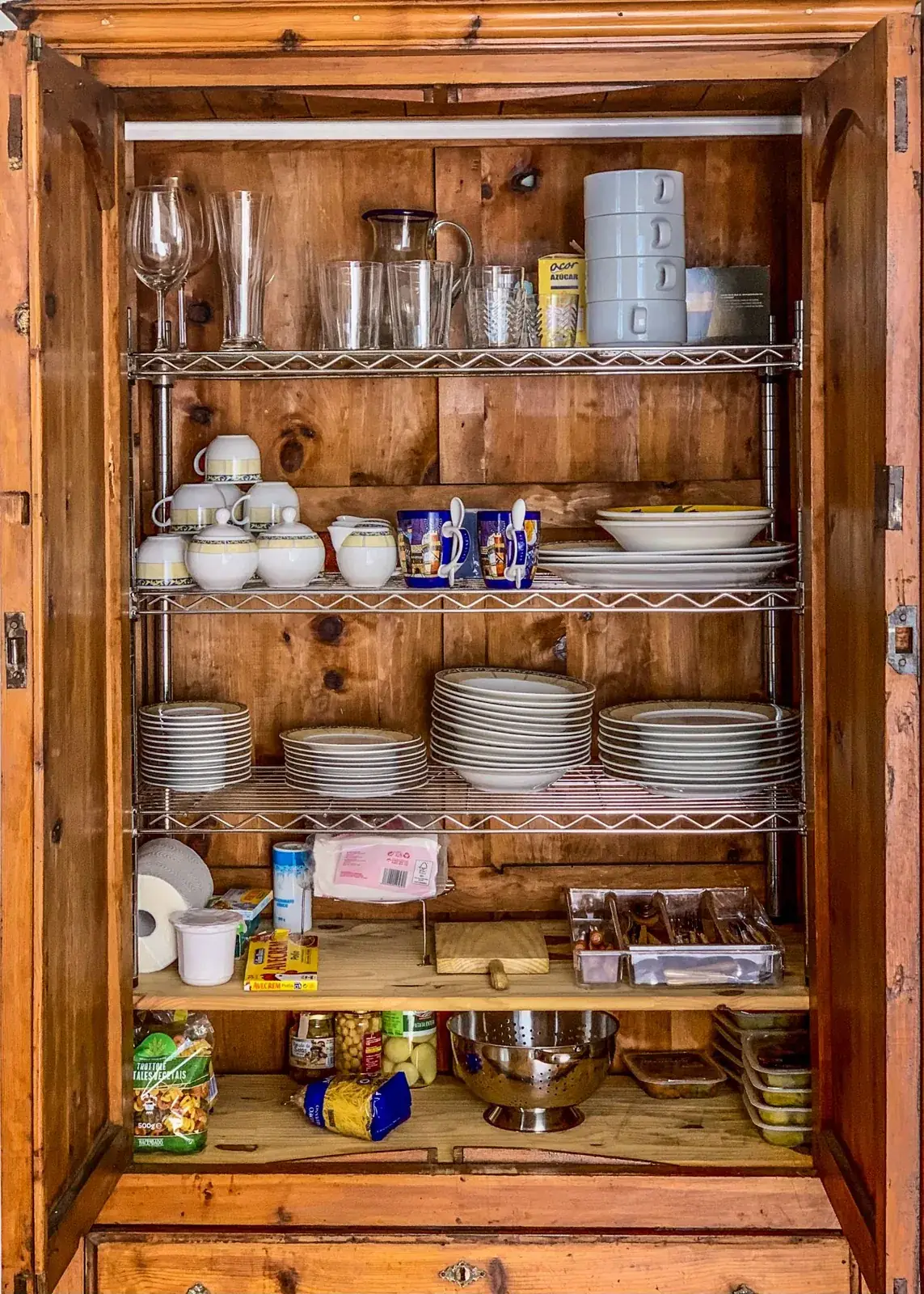 Kitchen cupboard with dishes, glassware and small containers