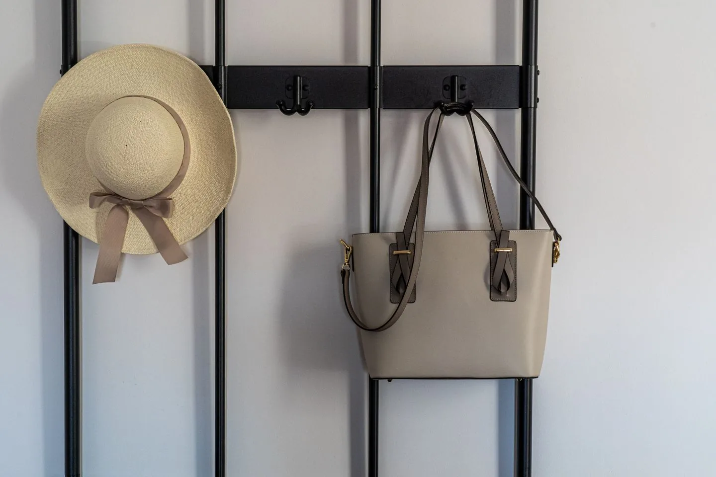 Hat and handbag hanging on hooks by the entrance