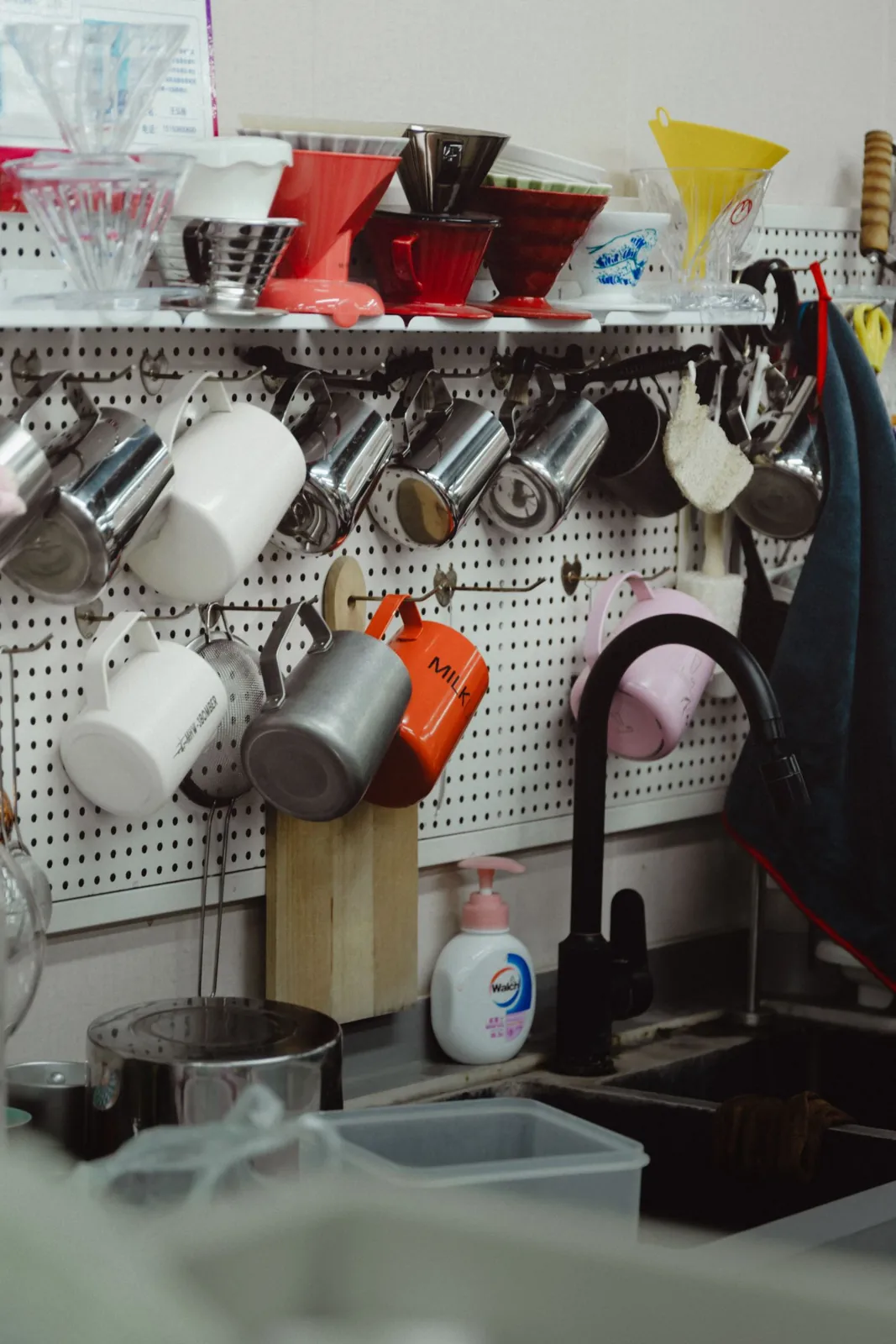 Kitchen mugs and tools arranged on a pegboard