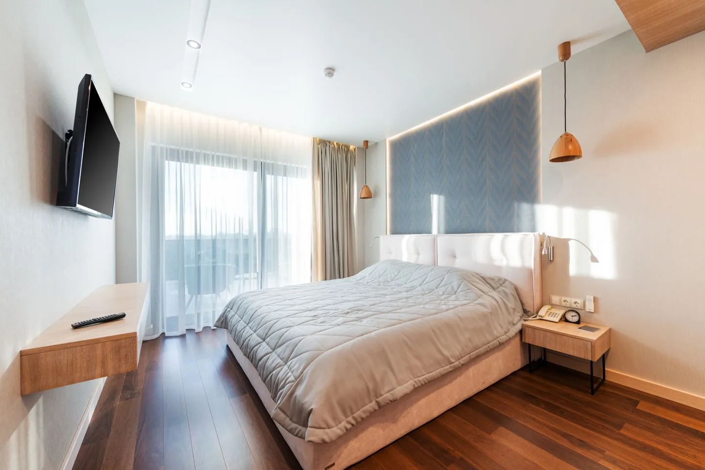 Made bed and bedside tables in a bright guest room