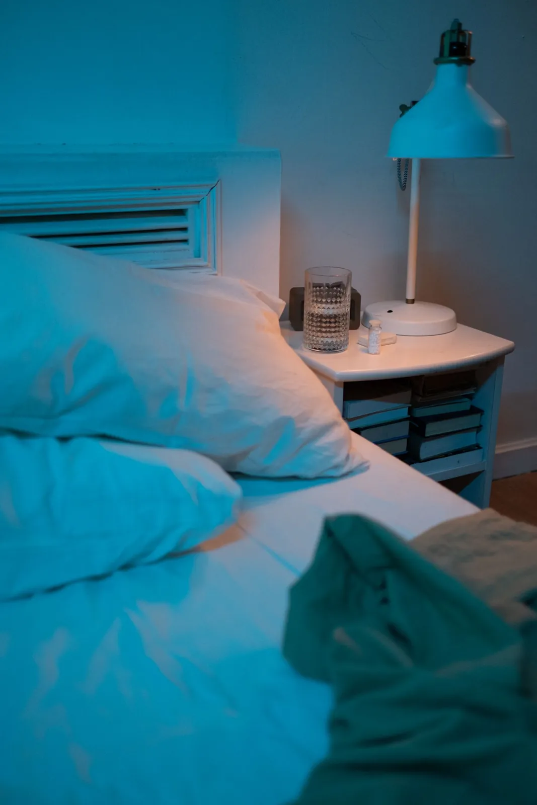 Bedside table with a lamp and glass of water