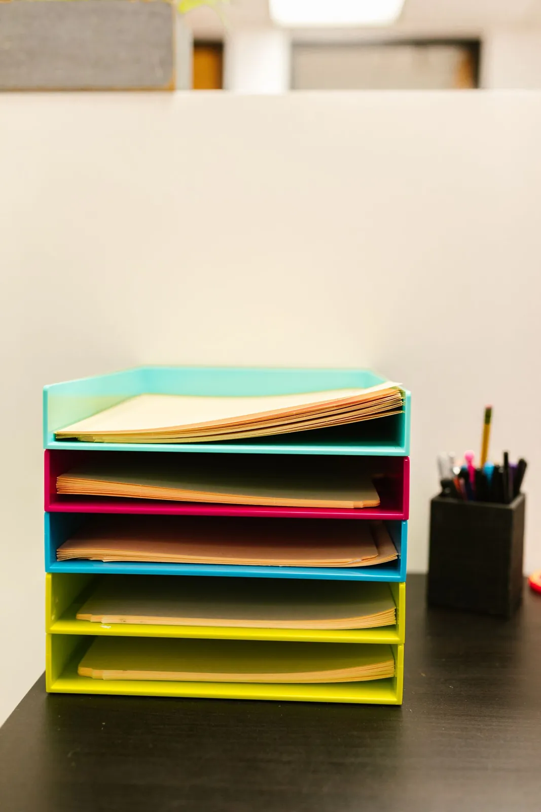 Stacked paper trays beside a pen holder