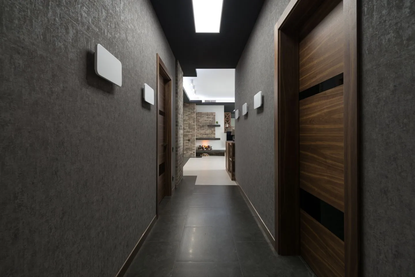 Long hallway leading towards a bright living space